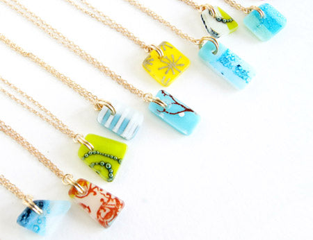 A limited assortment of delicate handmade recycled glass necklaces on gold chain 