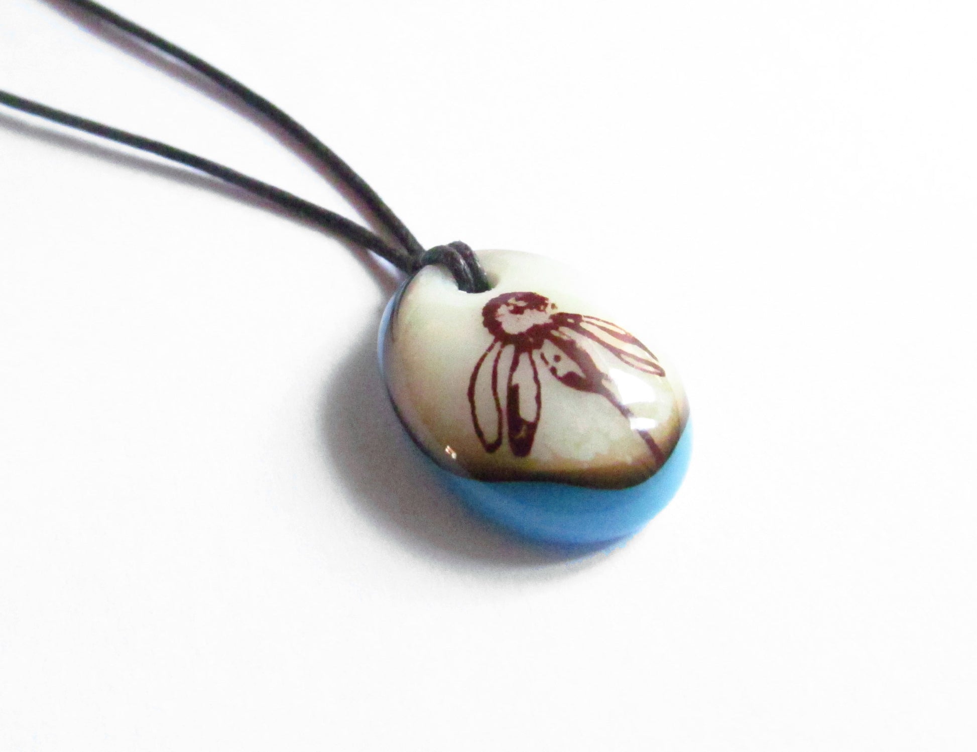 Botanical pendant on cotton cord necklace.