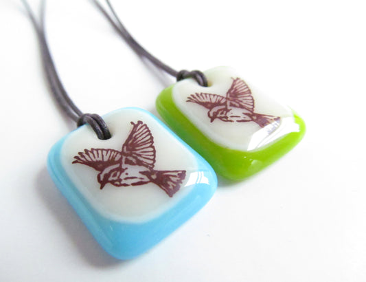 Bird in Flight pendants on cord necklaces.