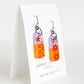 colorful orange and lavender purple glass earrings with sepia pattern design, handmade