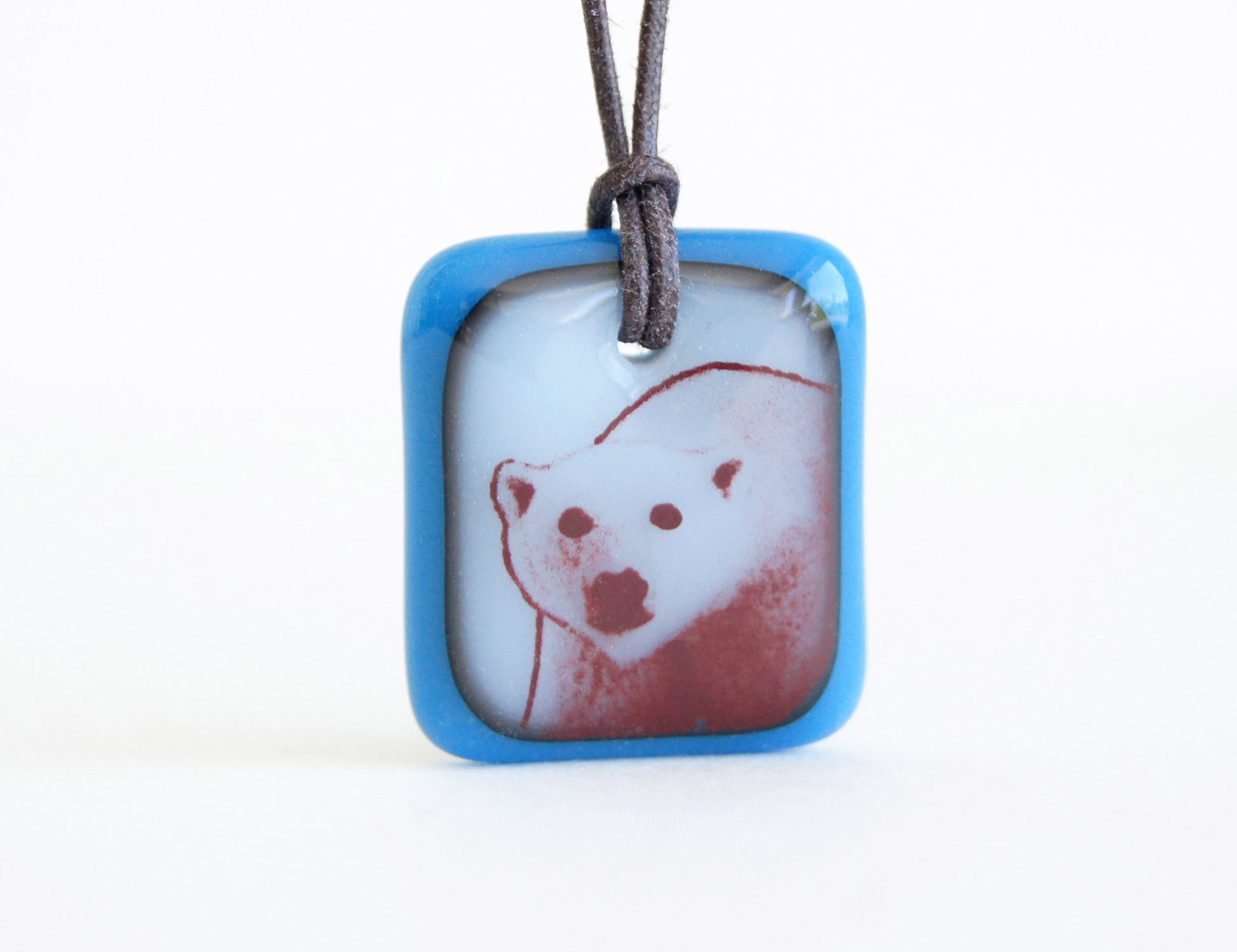 Polar bear necklace in royal blue and milk white glass.