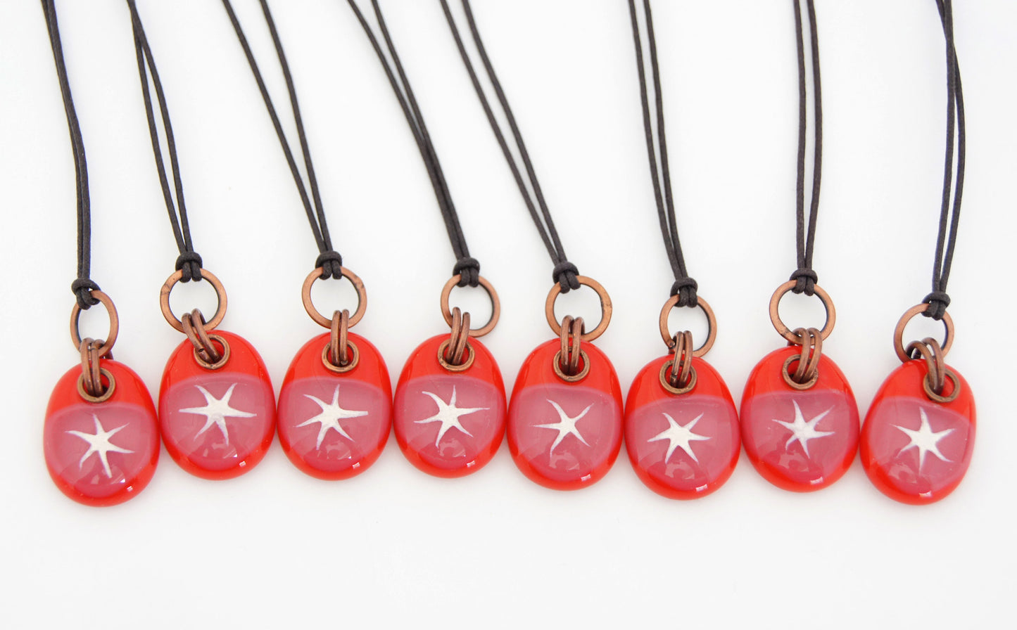 Handmade painted star pendants on cotton cord.