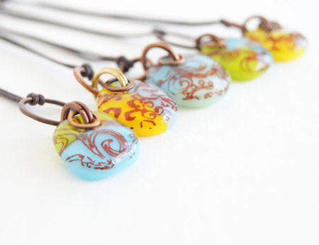 A selection of vintage style glass drops handmade with filigree scroll design, copper and brass on cotton cord. 