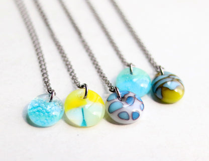 Four necklaces with colorful pendant beads on a white background