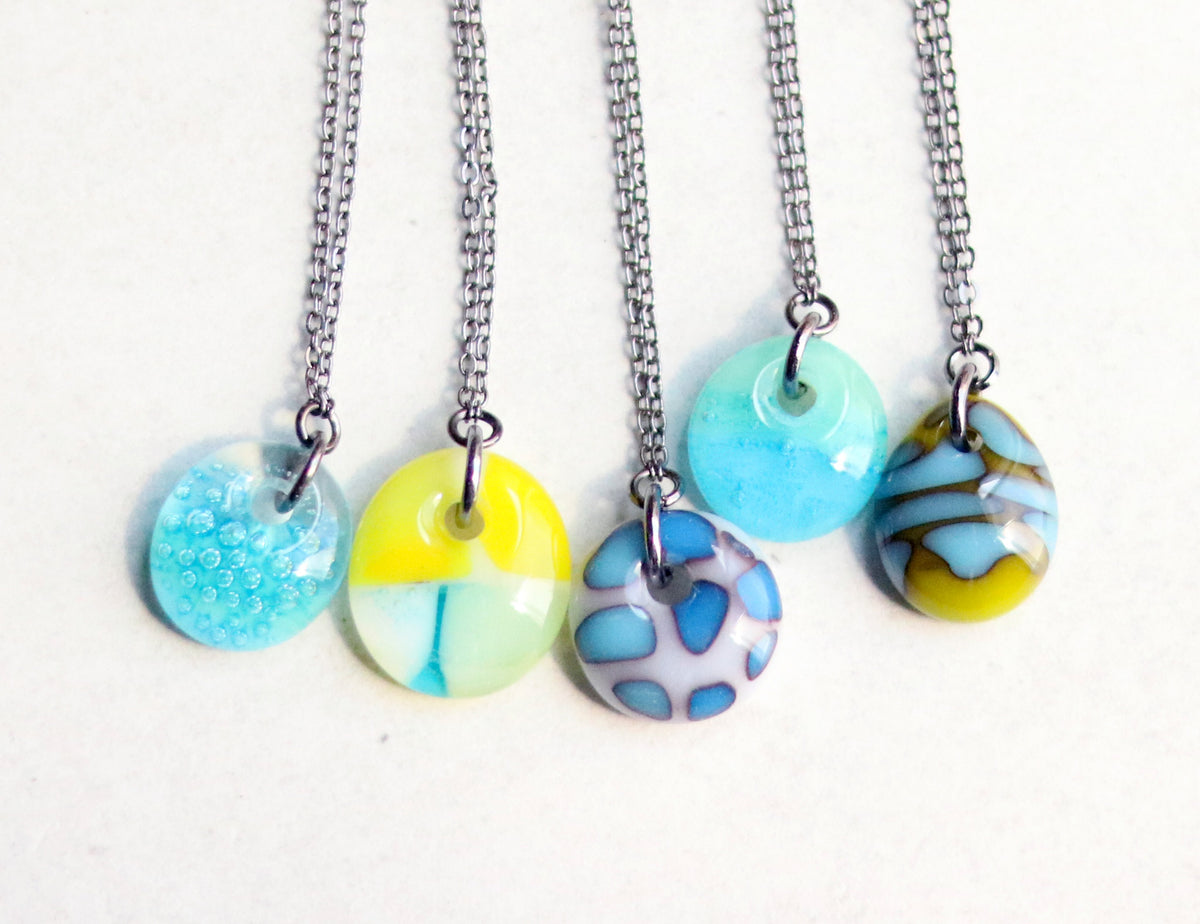 A group of necklaces with colorful pendant drops on a white background