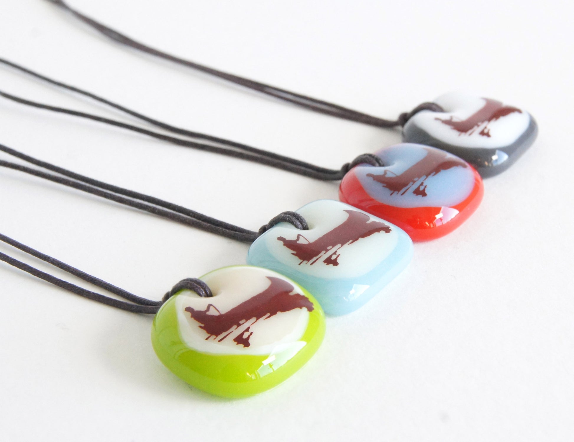 Handmade glass necklaces with canoe on a lake illustration.