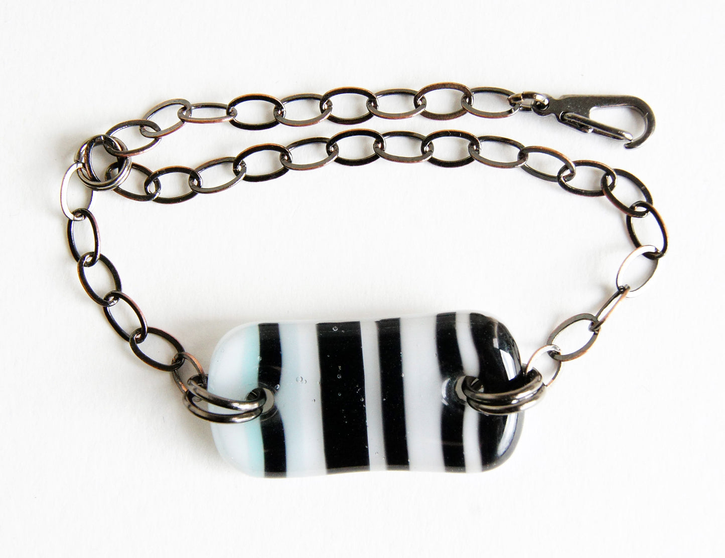 Fused glass bracelet with black stripes on white handmade by Leila Cools.