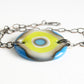 A fun bold glass and chain bracelet with a blue and green bullseye design.