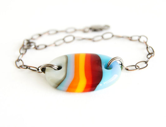 Handmade adjustable bracelet with multicolor striped glass oval bead.