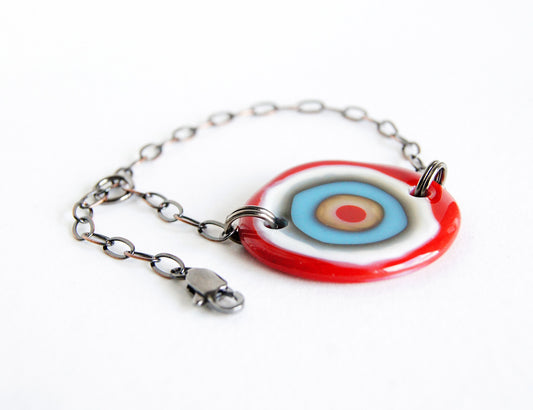 Adjustable chain bracelet with red and blue glass bullseye design