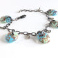 One of a kind adjustable fused glass bracelet with antiqued bronze chain and stainless steel tear drop beads.
