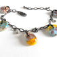 A fused glass bracelet with vintage style glass drops, filigree design and adjustable bronze chain.