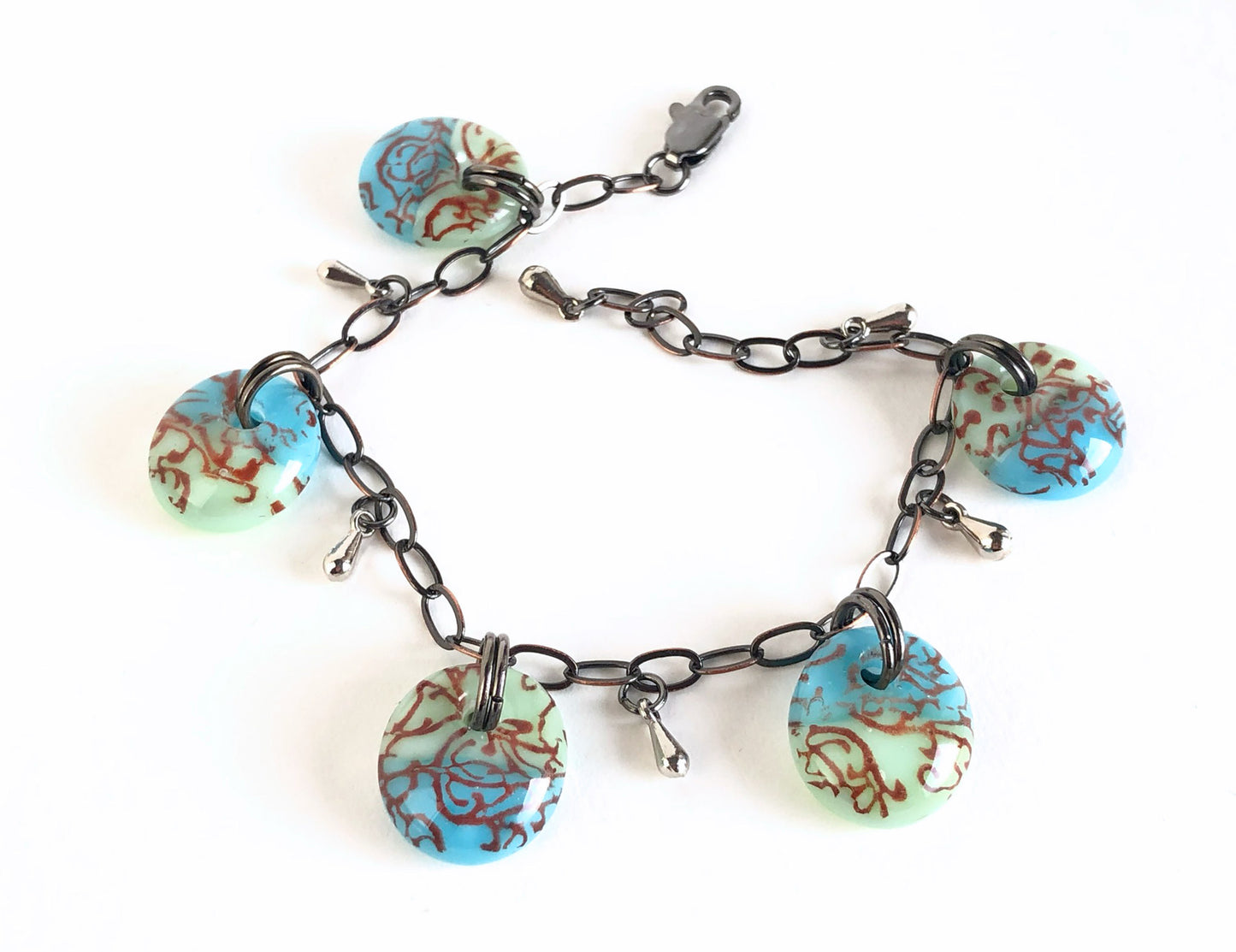 One of a kind fused glass charm bracelet with antiqued bronze chain and stainless steel teardrop beads.