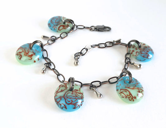 Green and aqua blue filigree design glass drop charm bracelet with dark copper chain.