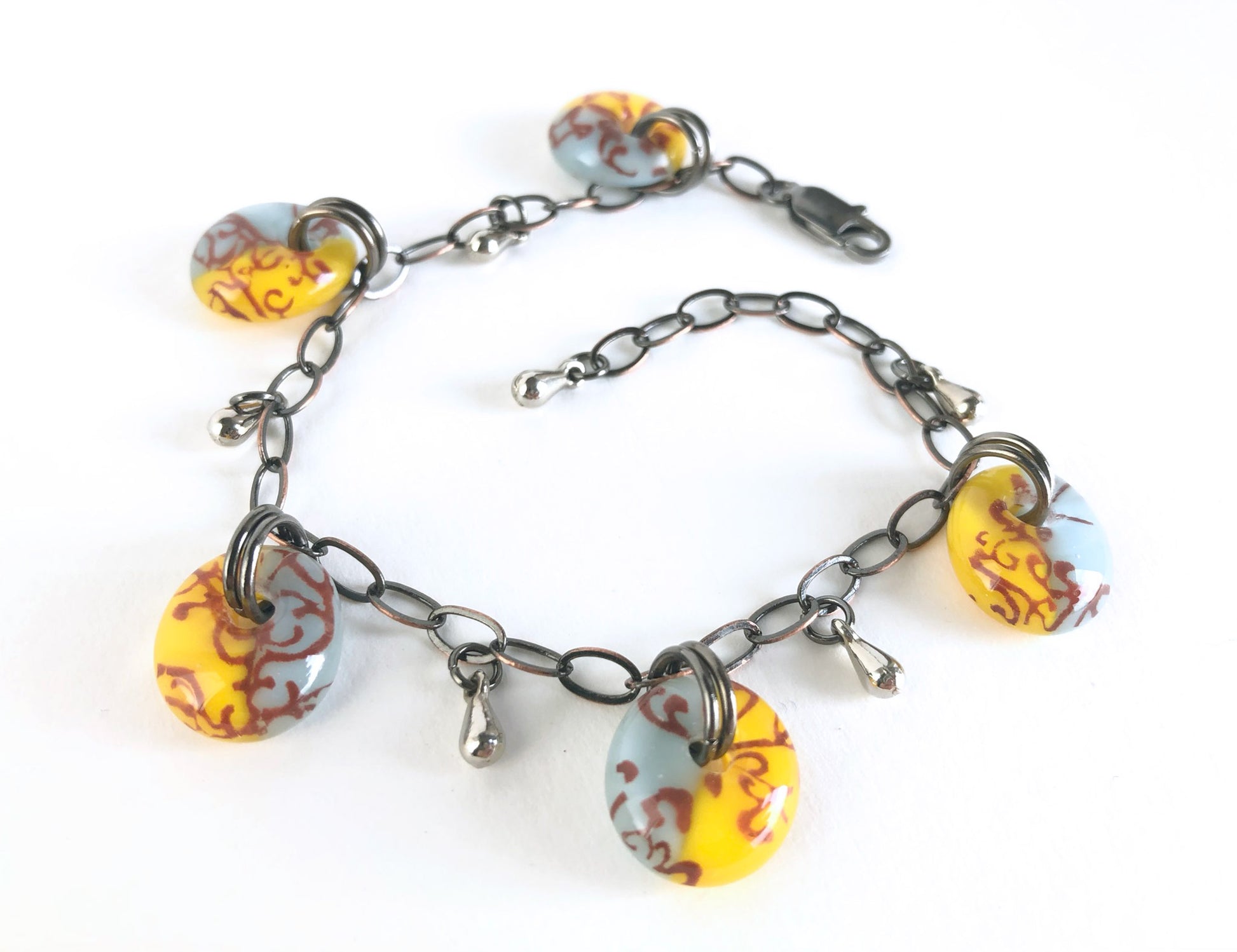 Adjustable antique bronze chain bracelet with vintage color glass drops.