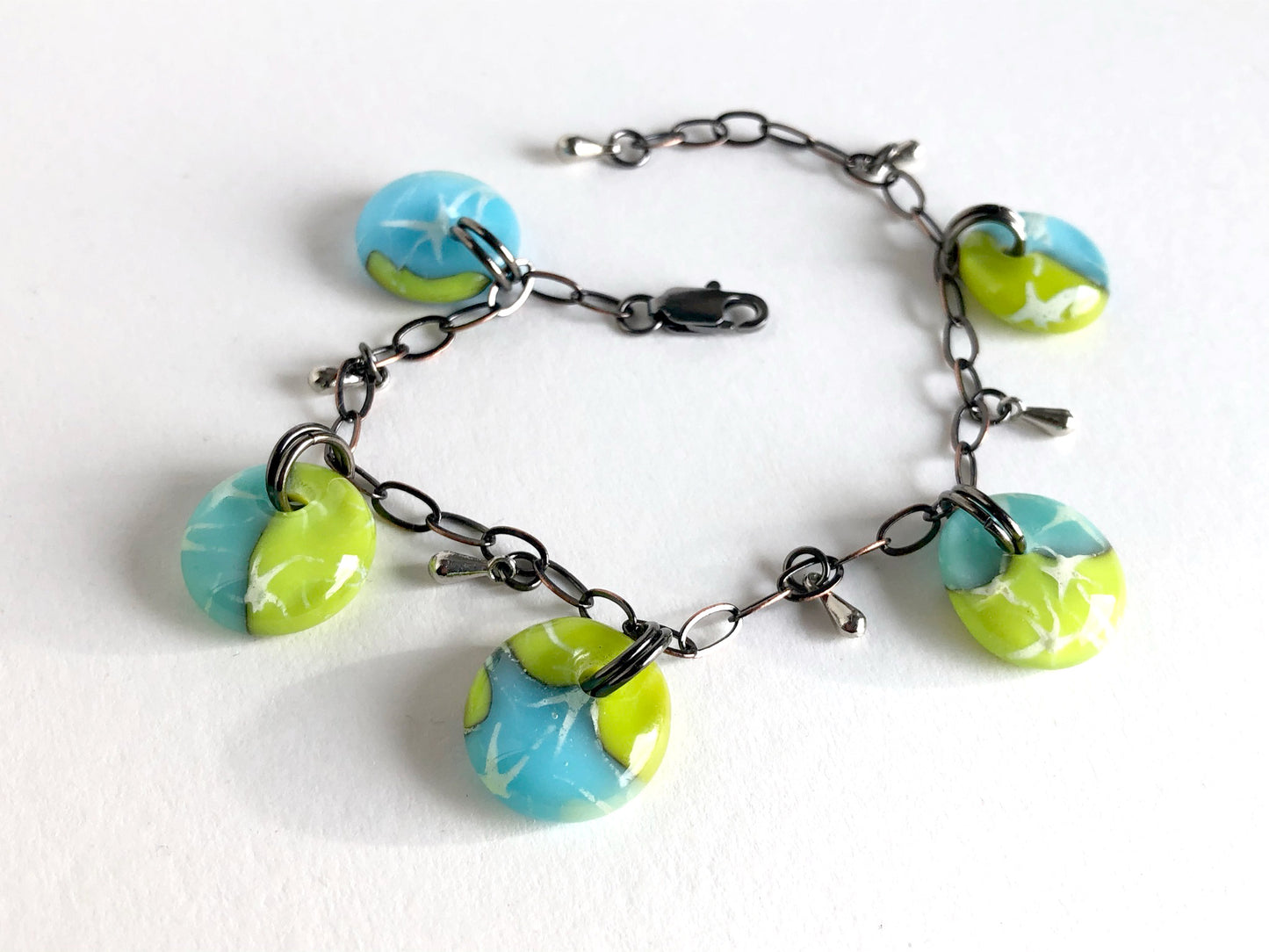 Glass drop bracelet in aqua blue and light olive green / chartreuse with painted silver stars