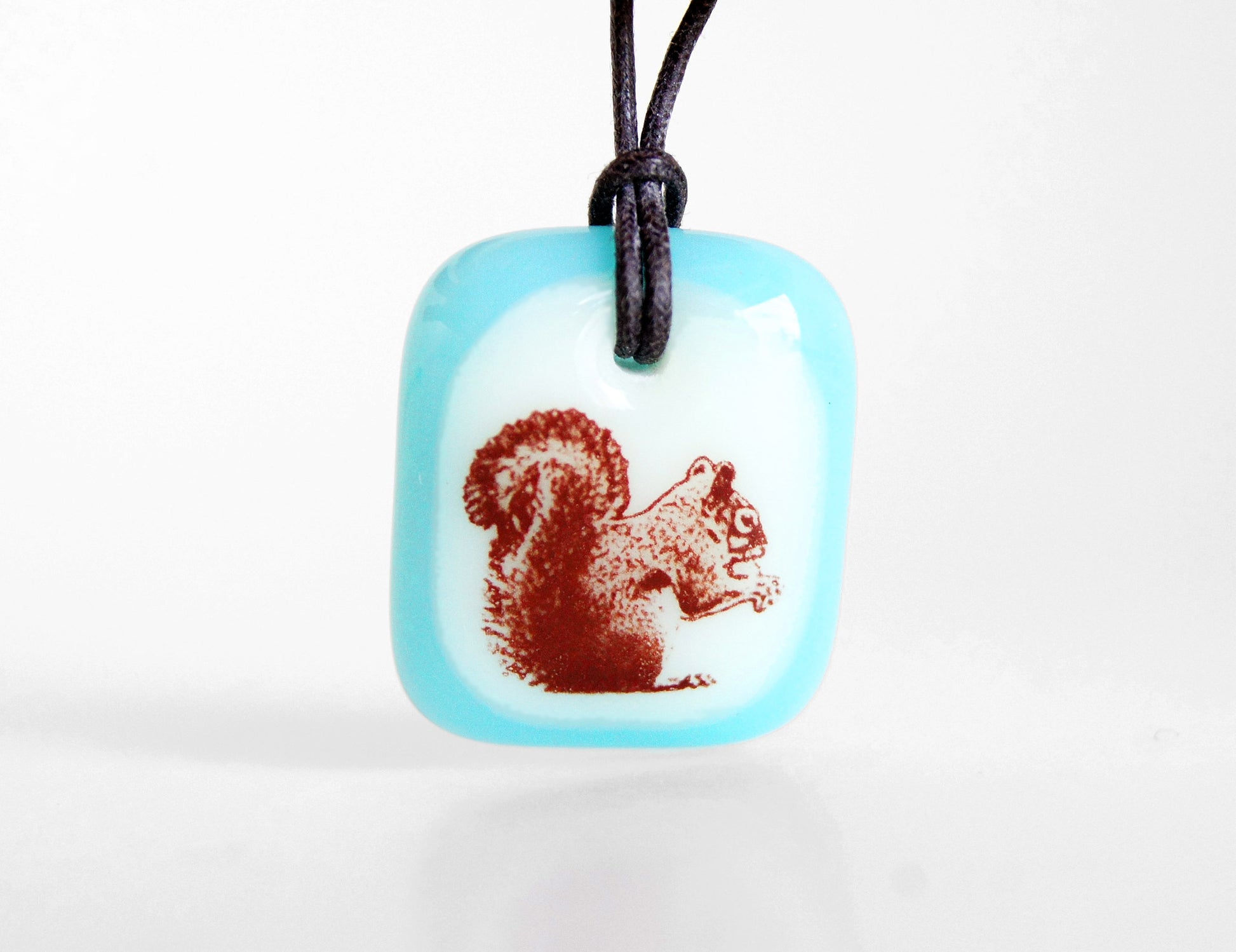 Squirrel necklace in ice blue.