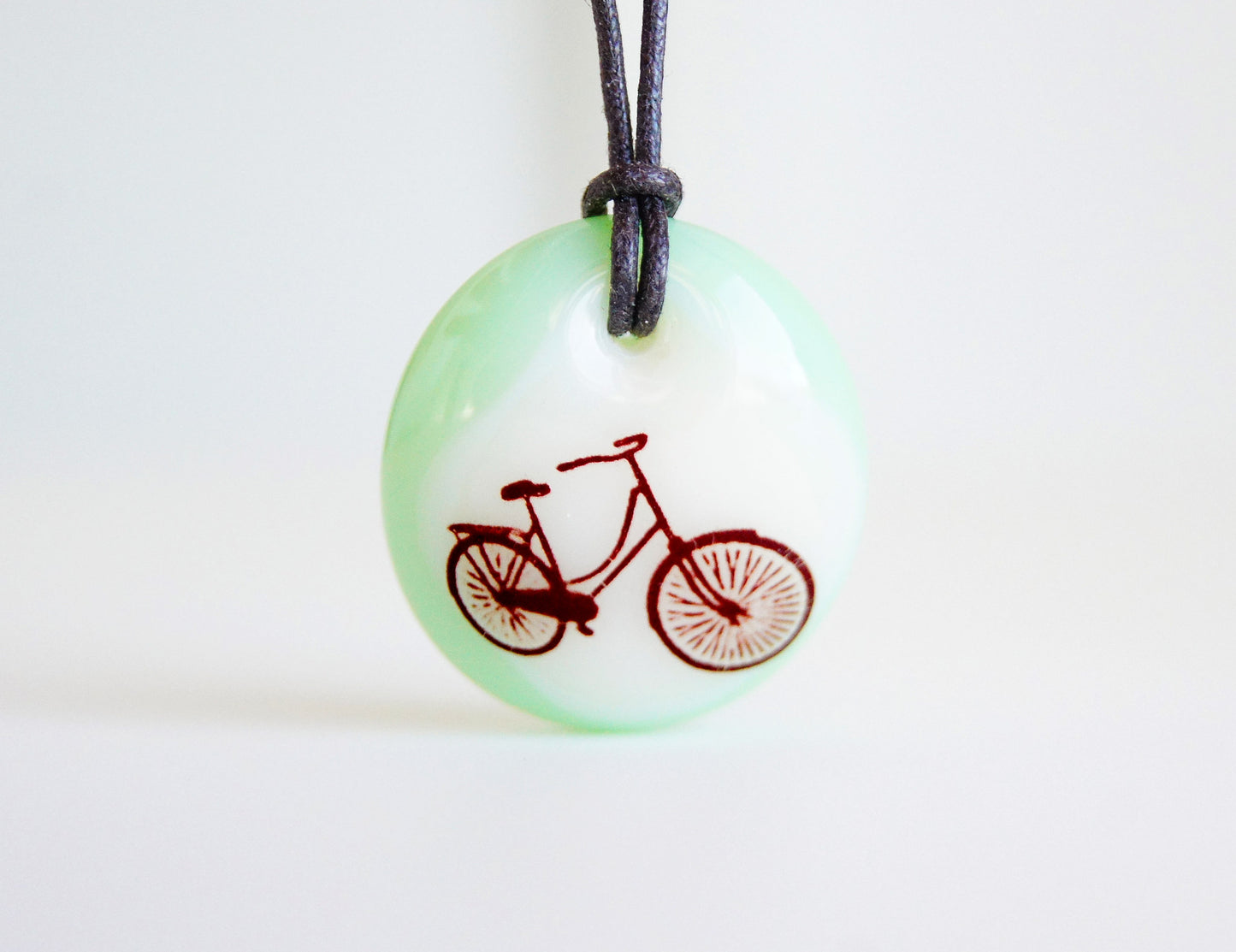 Bicycle pendant necklace in mint green.